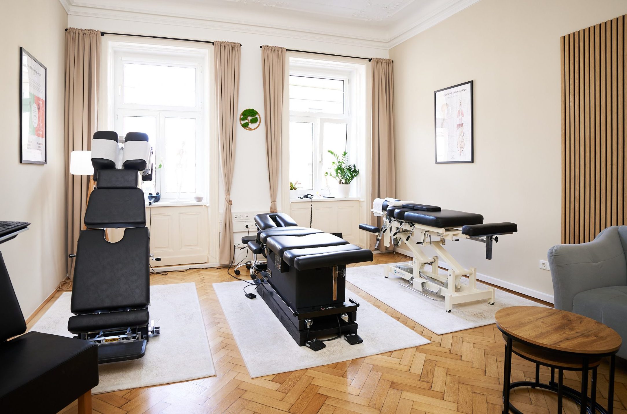 Ein heller, moderner Behandlungsraum im ChiroZentrum Wien mit drei Chiropraktik Liegen.