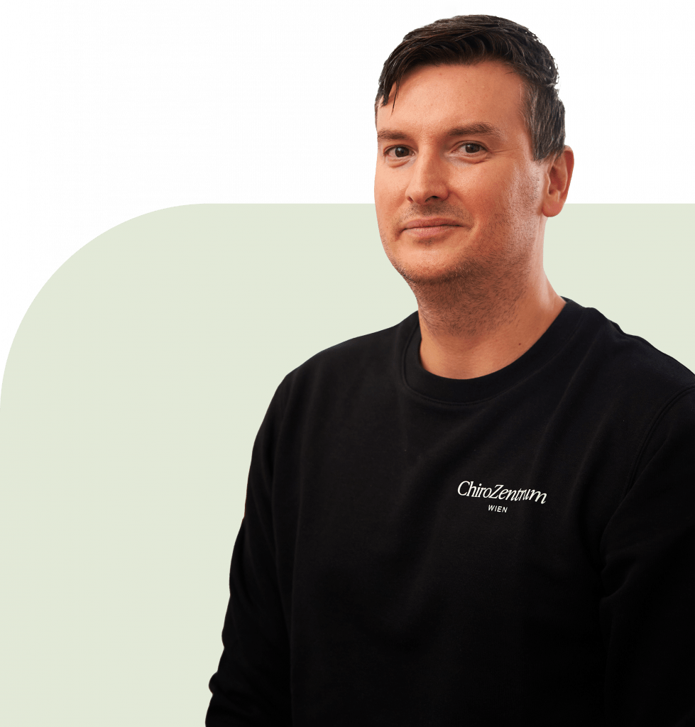 Chiropraktor Marek Sukenik vom ChiroZentrum Wien lächelt in die Kamera.