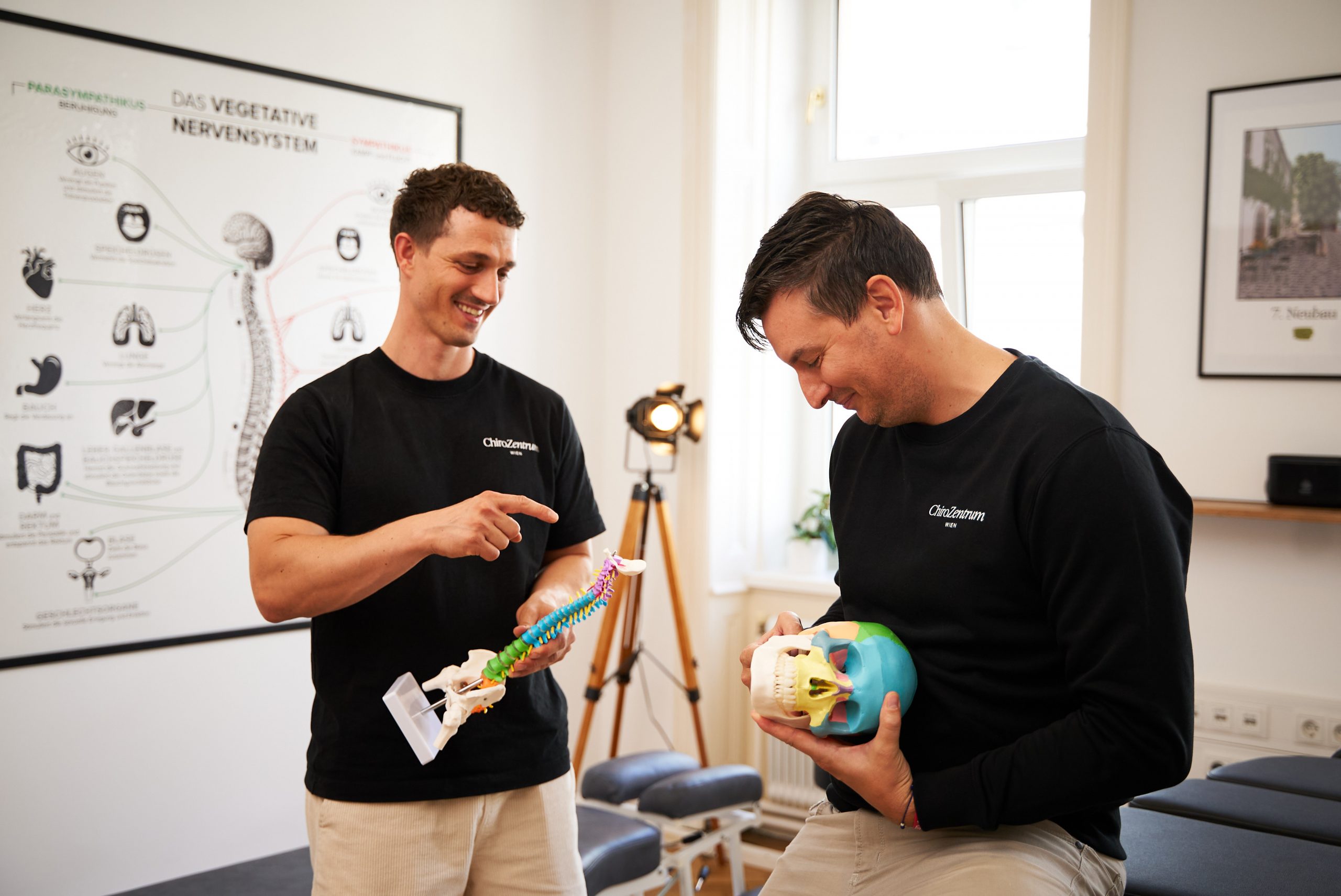 Felix Trescher und Marek Sukenik zeigen auf Modelle von Knochen